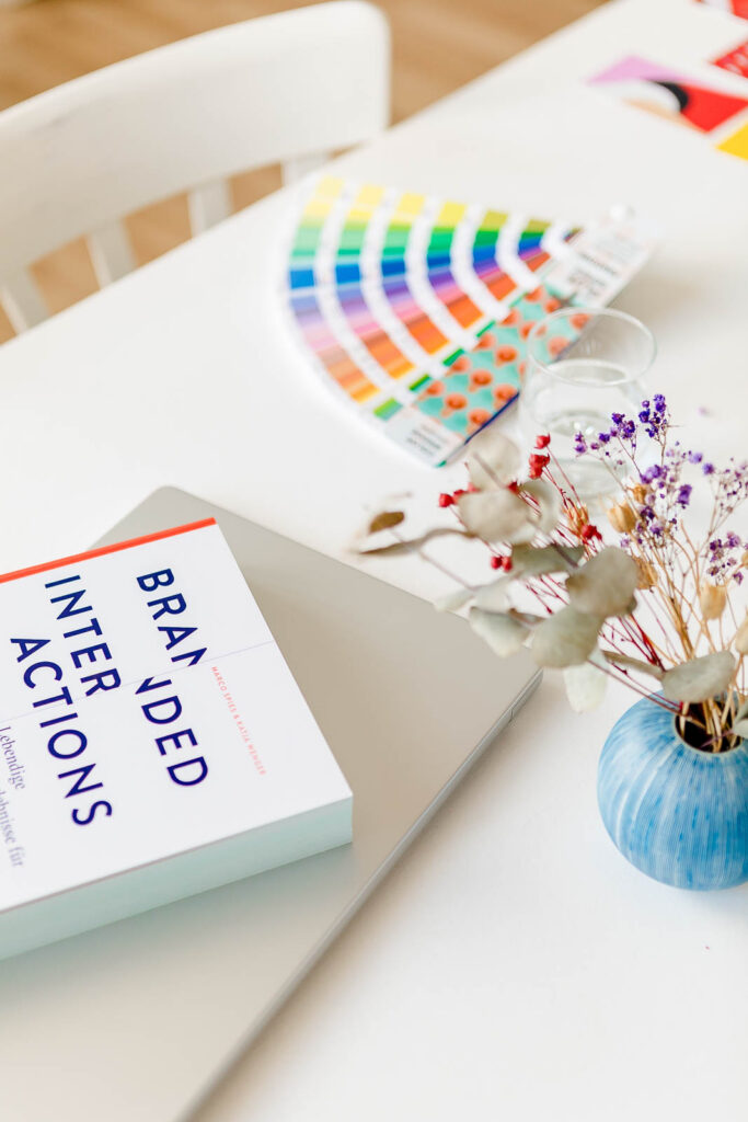 Pantone-Farbfächer und Designbücher auf dem Schreibtisch von Studio Sara